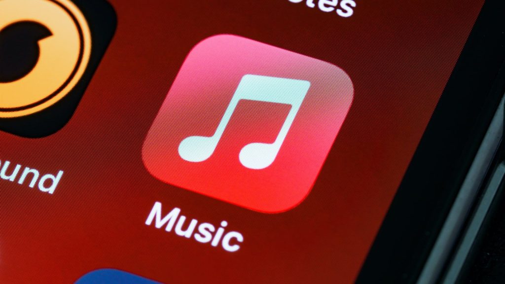 Apple Music will soon let you share songs and lyrics to your WhatsApp status as the fight against Spotify continues The Apple Music app icon against a red background on an iPhone.