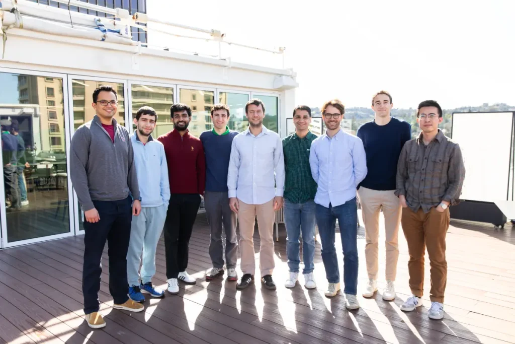 Inception raises $50 million to build diffusion models for code and text A group of nine men stand on a sunlit balcony.