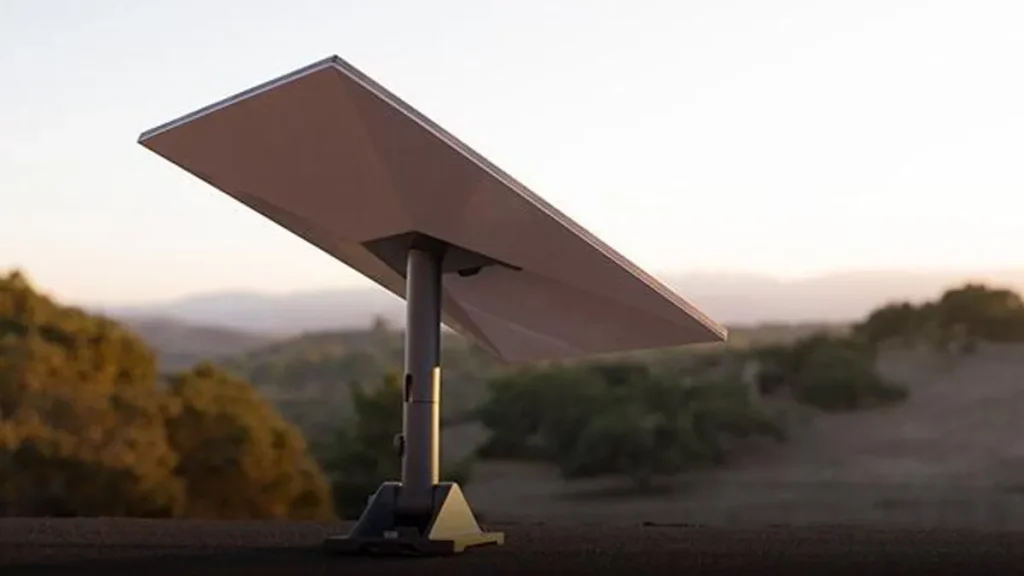 a Starlink satellite dish sits in the foreground, angled at 30 degrees, while hills and mountains dotted with green tees sit in the unfocused background